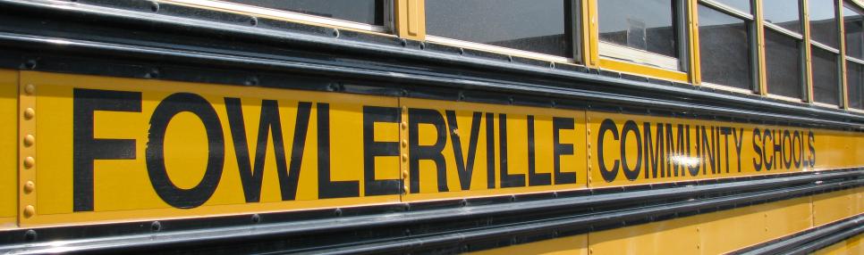 Close up of the side of a Fowlerville Community Schools bus.